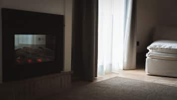 Ein Wohnzimmer mit Kamin, einer Couch und einem Teppich.