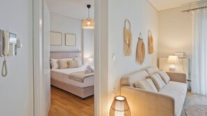A modern bedroom with a bed, bedside table, and a hanging light fixture. - Modern Beach Retreat 2BR in Coastal Palaio Faliro (Paleo Faliro)