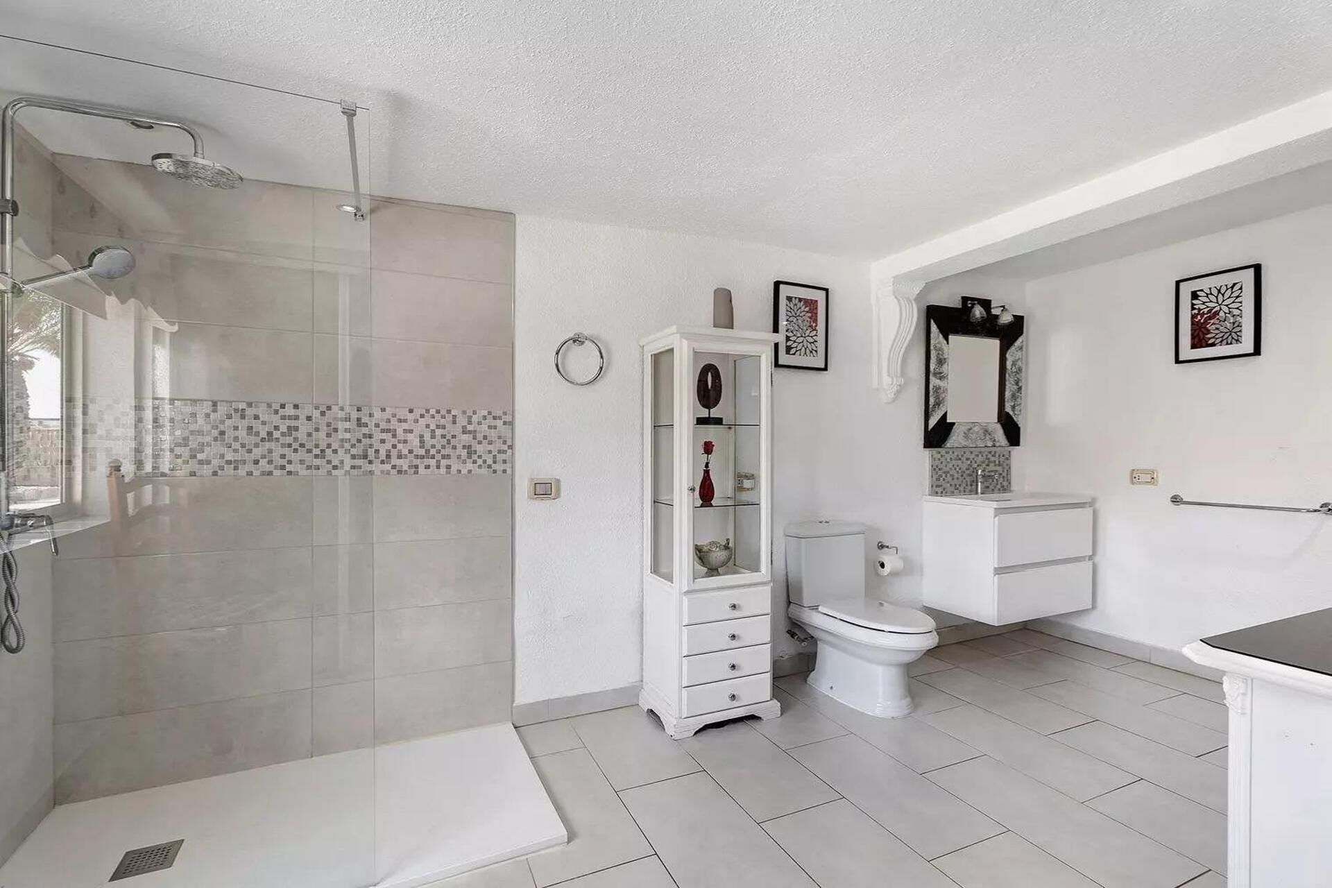 A modern bathroom with a shower, toilet, and sink.
