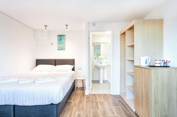 A bedroom with a bed, bedside table, and a wooden wardrobe.