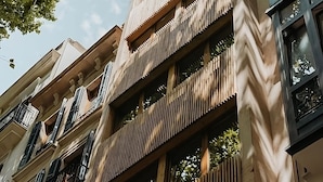Ein mehrgeschossiges Gebäude im modernen Architekturstil, mit Balkonen und großen Fenstern.