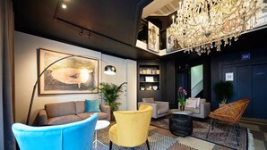 A modern lobby with a chandelier, sofas, a bookshelf, and a large painting. - Relaxing Room with Kitchenette | Quick Access to Local Attractions (Oostende)