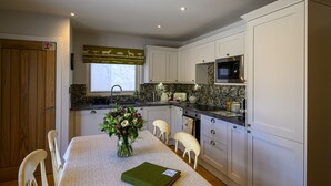 Una cocina moderna con armarios blancos, un microondas y un lavamanos.