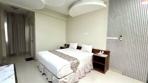 A hotel room with a large bed, a bedside table, a nightstand, and a wardrobe. - Dancenter Muscat Holiday Luxury Stay (Seeb)