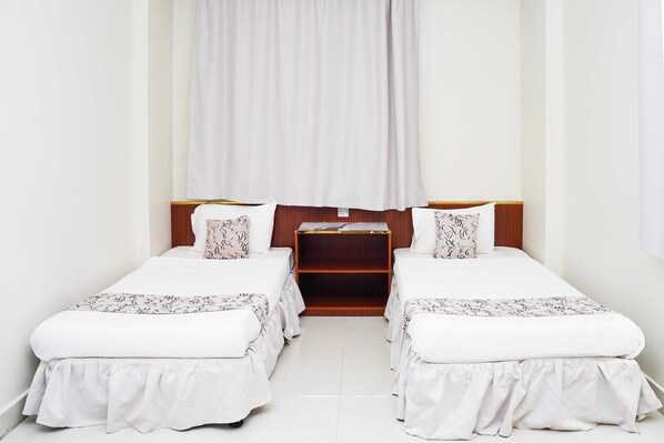 A double room with two beds, each with a white bedspread and matching pillows, a wooden nightstand, and a white curtain. - Dancenter Muscat Holiday Luxury Stay (Seeb)