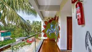 A corridor with a wooden floor, a glass railing, a mural, and a fire extinguisher. - Classic Celeb Da Luna (Chopdem)