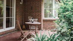 A brick exterior with a window, a wooden table with a bottle, and a broom leaning against the wall. - Holiday Home 'Kleinod' with Mountain View, Shared Terrace and Wi-Fi (Naumburg)