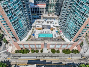 A high-rise building with a rooftop pool, multiple floors, and a central courtyard.
