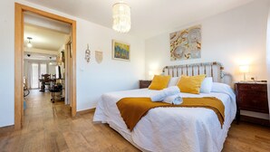 Ein Schlafzimmer mit einem Bett, Holzboden und einer Pendelleuchte.