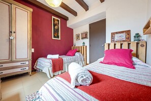 A bedroom with two beds, a wardrobe, and a door. - Holiday Home 'Tranquil' with Mountain View, Wi-Fi and Air Conditioning (El Lloar)