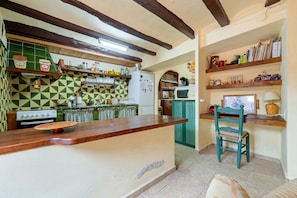 A kitchen with a wooden countertop, a green and white checkered backsplash, a stove, and a microwave. - Holiday Home 'Tranquil' with Mountain View, Wi-Fi and Air Conditioning (El Lloar)
