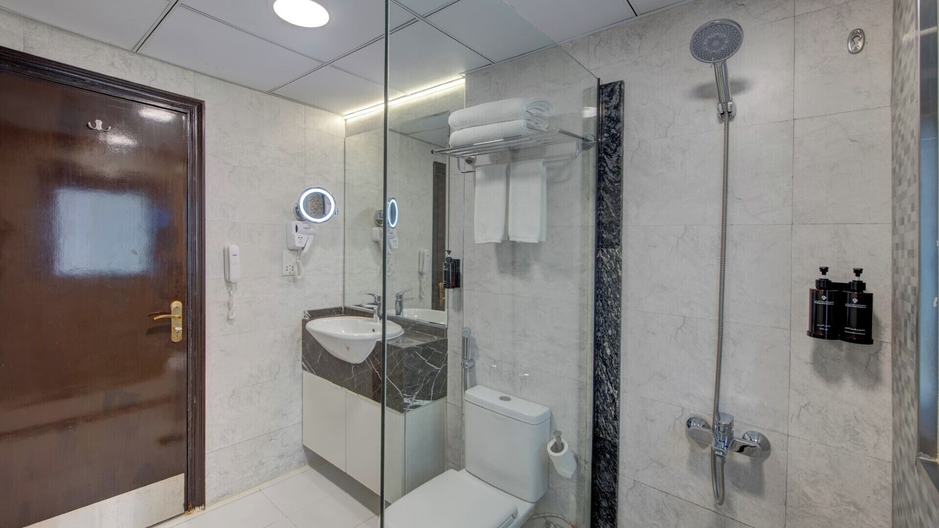 Une salle de bain moderne dotée d’une douche à parois de verre, de toilettes, d’un lavabo et d’un meuble-lavabo.