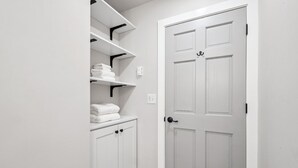 A white closet with shelves and a door.