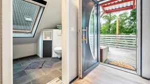 A modern bathroom with a skylight, a toilet, and a shower area. - Apartment 'Kanal' with Private Terrace and Wi-Fi (Steinau)