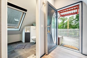 Une salle de bain moderne avec un puits de lumière, des toilettes et un espace douche.