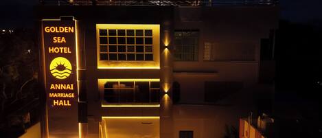 A building with a sign for the Golden Sea Hotel and Annai Marriage Hall.