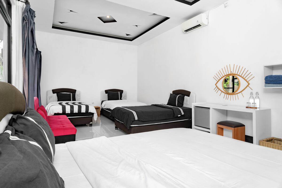Una habitación de hotel moderna con dos camas, un escritorio y un ventanal grande.