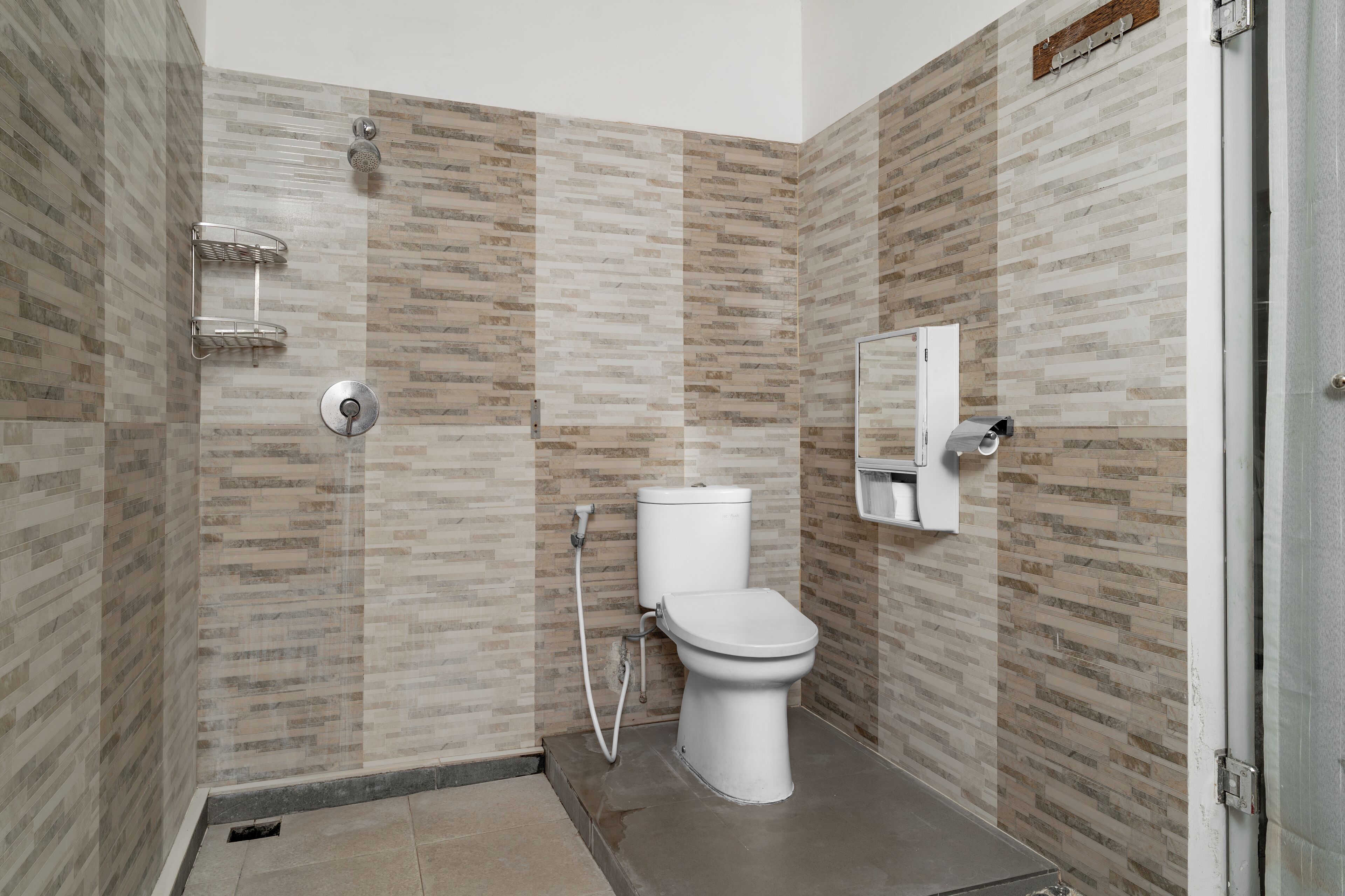 A bathroom with a toilet, shower, and a towel rack.
