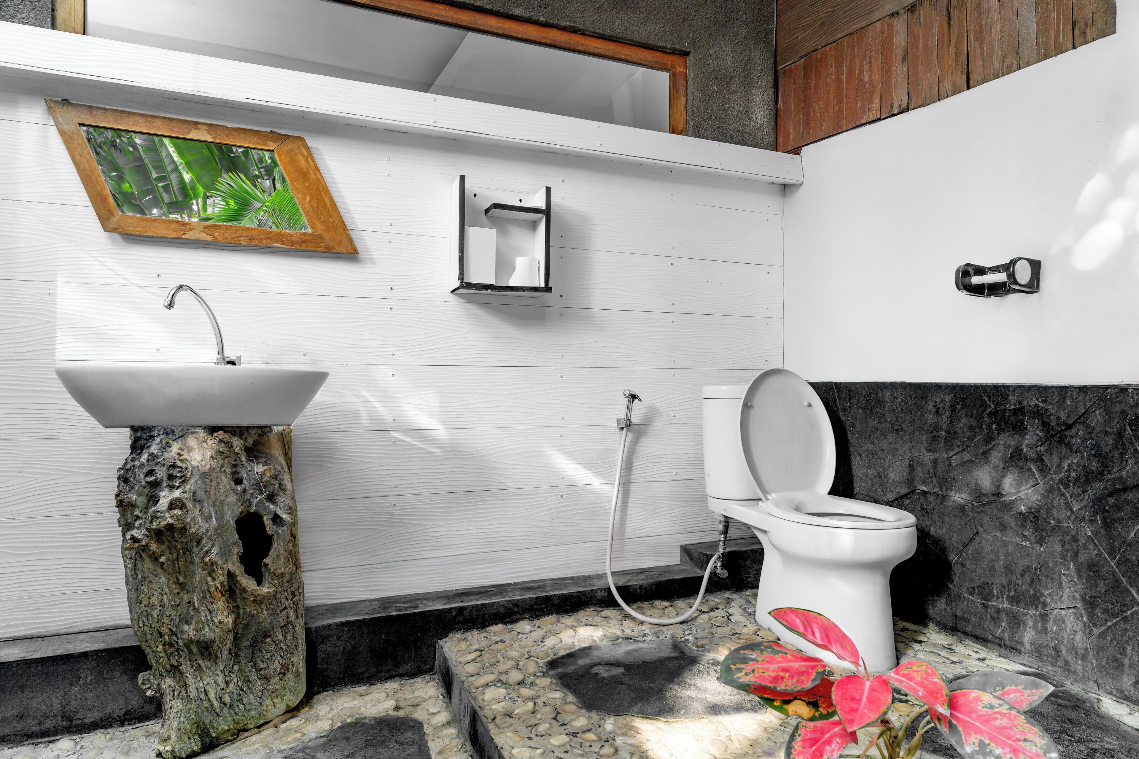 A bathroom with a white sink, a toilet, and a shower.