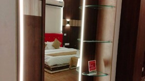 Una habitación de hotel con una cama, una mesita de noche y un espejo.