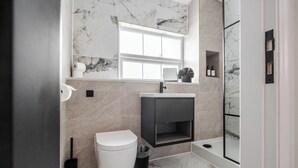 A modern bathroom with a toilet, sink, and shower area.