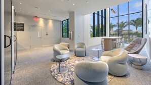 A modern interior with a glass partition, a round coffee table, and a seating area with chairs. - NOK Amazing 1 BR in Miami Beach (Miami Beach)