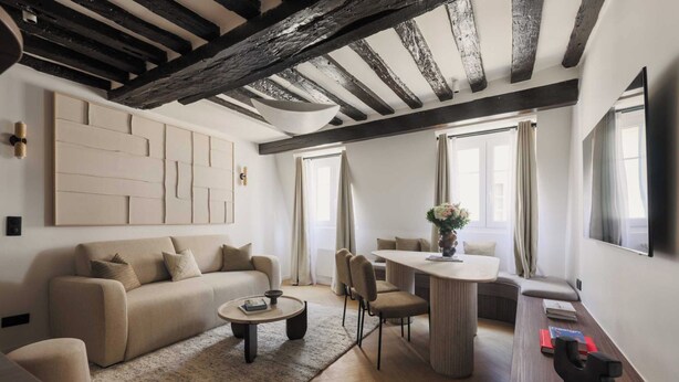 Una sala de estar moderna con sofá, mesa de centro y comedor.