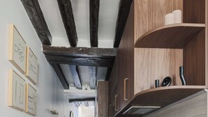 Un pasillo estrecho con armarios de madera y suelo de madera.