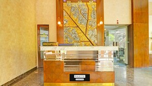 Un comptoir d’accueil avec une pancarte indiquant « Réception », une autre indiquant « Bureau administratif » et une troisième indiquant « Services de l’entreprise ».
