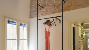 A room with a bed, a hanging clothes rack, a radiator, and a window with blinds. - Bright apartment in the historic center Santo Spirito fully restored (Firenze)