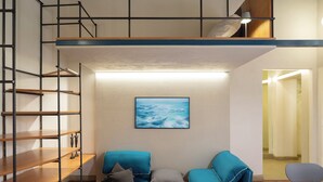 A loft-style room with a mezzanine, a sofa, a small table, and a painting on the wall. - Bright apartment in the historic center Santo Spirito fully restored (Firenze)