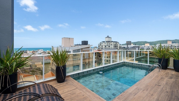 Une piscine sur le toit offrant une vue dégagée sur la mer et les bâtiments environnants.