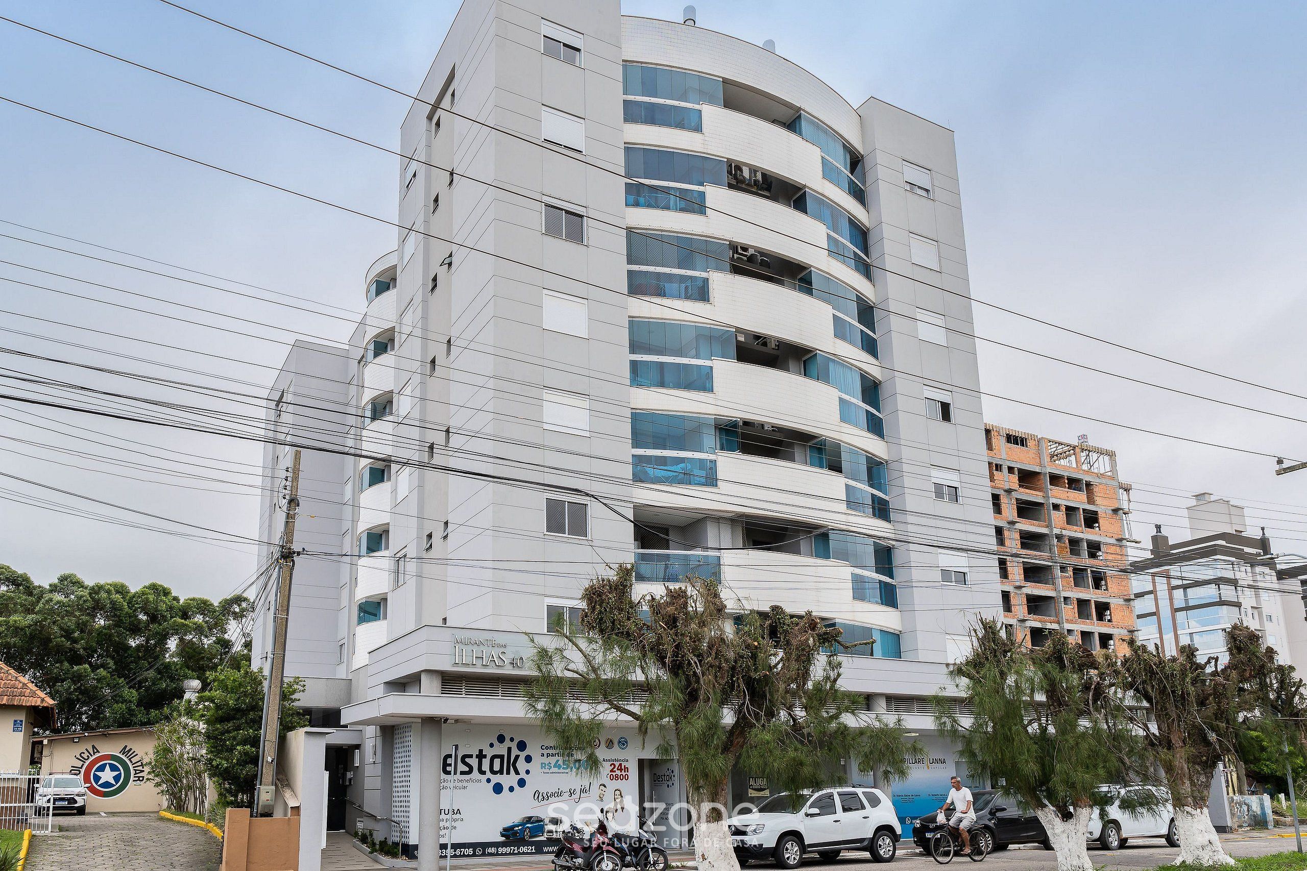 A multi-story building with a modern design, featuring balconies and large windows.