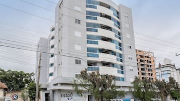 A multi-story building with a modern design, featuring balconies and large windows.
