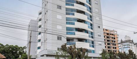 A multi-story building with a modern design, featuring balconies and large windows.