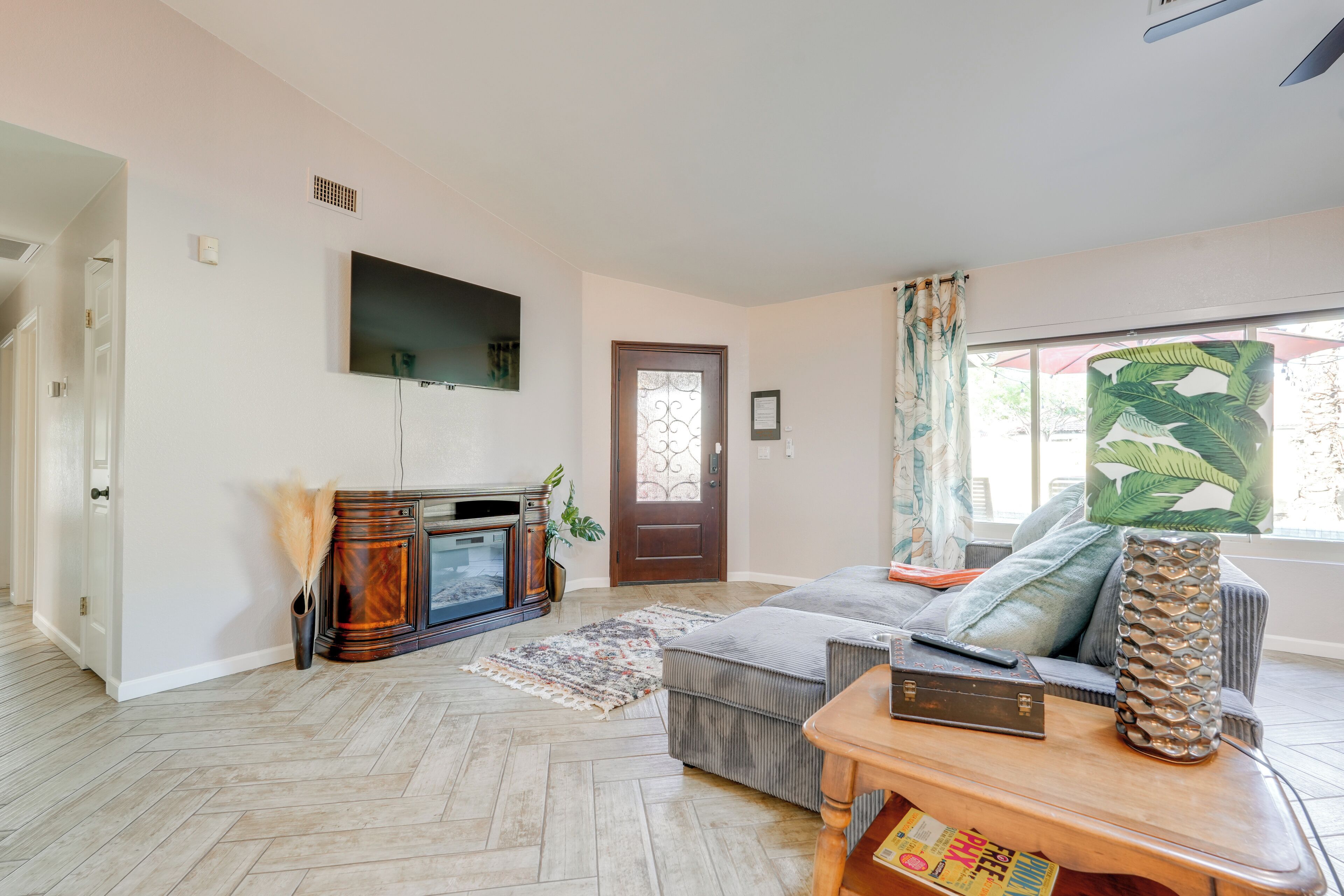 Ein Wohnzimmer mit Kamin, einer Couch, einem Couchtisch und einem an der Wand montierten Fernseher.