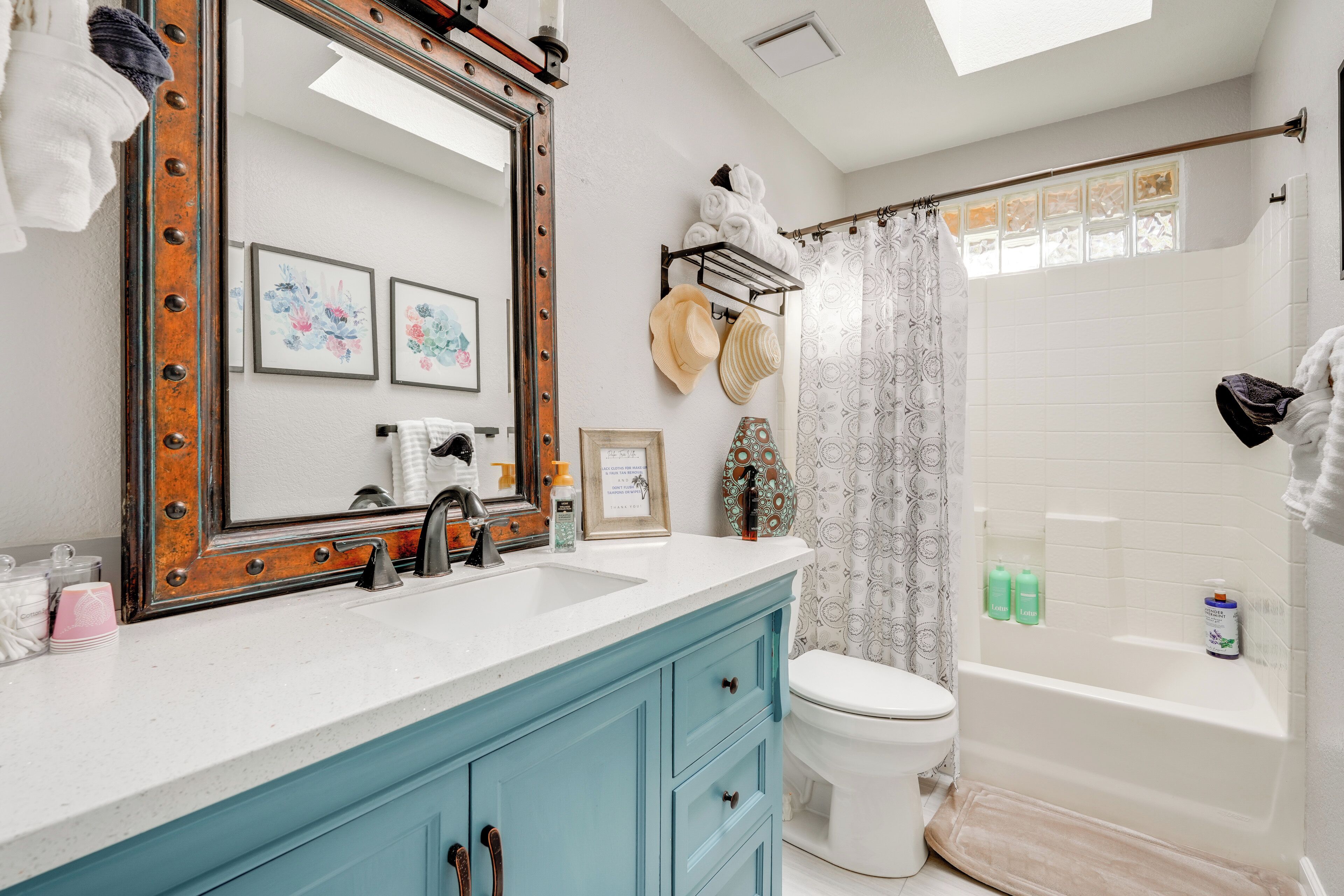 A bathroom with a large mirror, a sink, a toilet, and a bathtub.