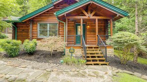 A log cabin with a green roof, a front porch, and a stone pathway leading to the entrance. - 1 Mi to Dtwn Gatlinburg: Hot Tub Haven in Smokies! (Gatlinburg)