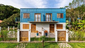 A two-story house with a blue exterior, white lower level, and wooden doors and shutters. - 3BR House w/ BBQ 800m From Beach Rju8301 (Bombinhas)
