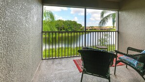A balcony with a view of a water body and greenery.