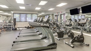 A gym with multiple treadmills, exercise bikes, and weight machines.