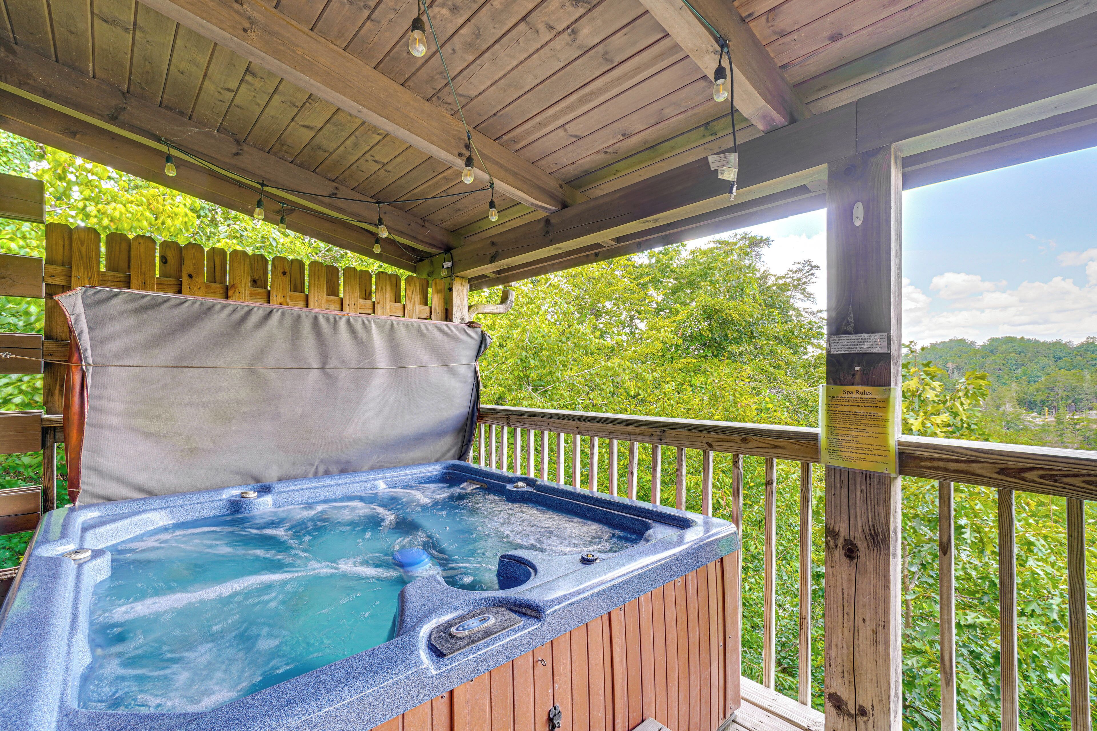 A hot tub on a wooden deck with a view of trees.