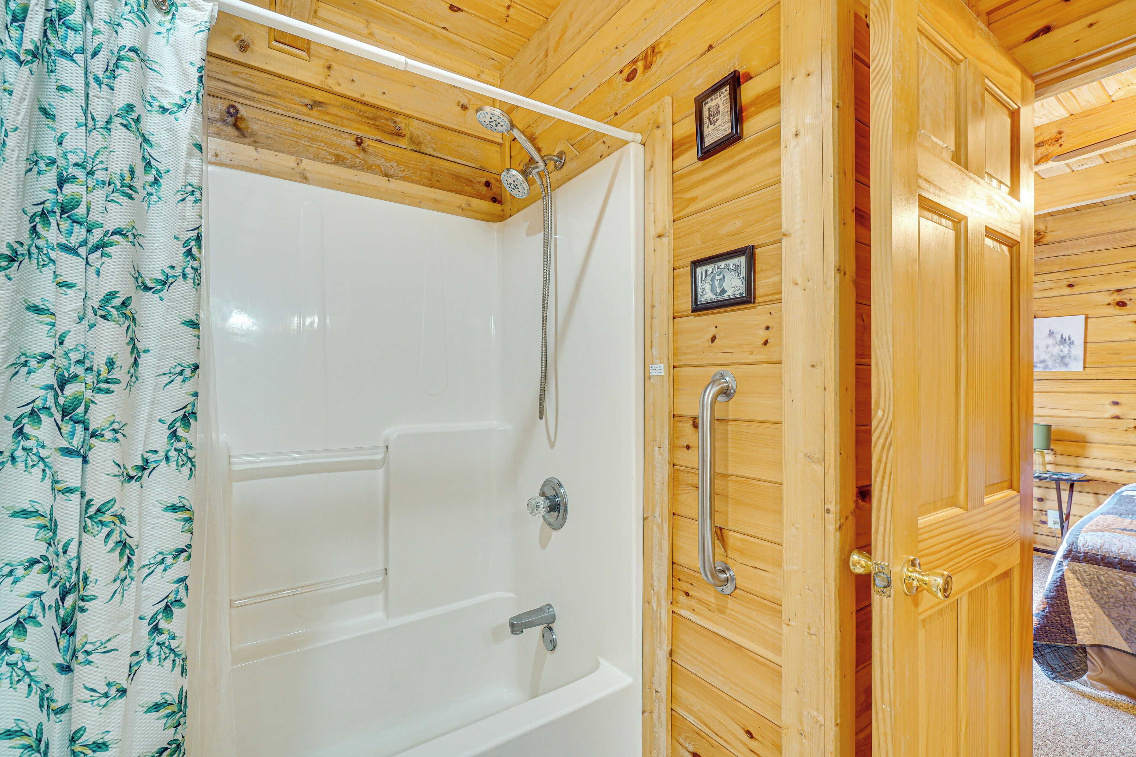 Ein Holzblock-Interieur mit einer weißen Badewanne, Holzwänden und einer Tür mit Griff.