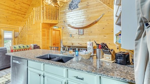 A kitchen with granite countertops, a built-in dishwasher, and wooden cabinetry. - Douglas Lake Access: Family Cabin in Sevierville! (Sevierville)