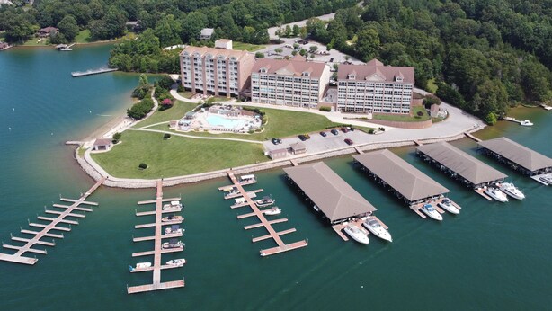 Eine Luftaufnahme eines Hotels mit mehreren Gebäuden, einer Marina mit angestaubten Booten und einer großen Grünfläche.