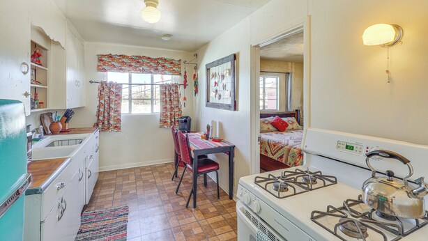 A compact kitchen with a stove, sink, and dining area.