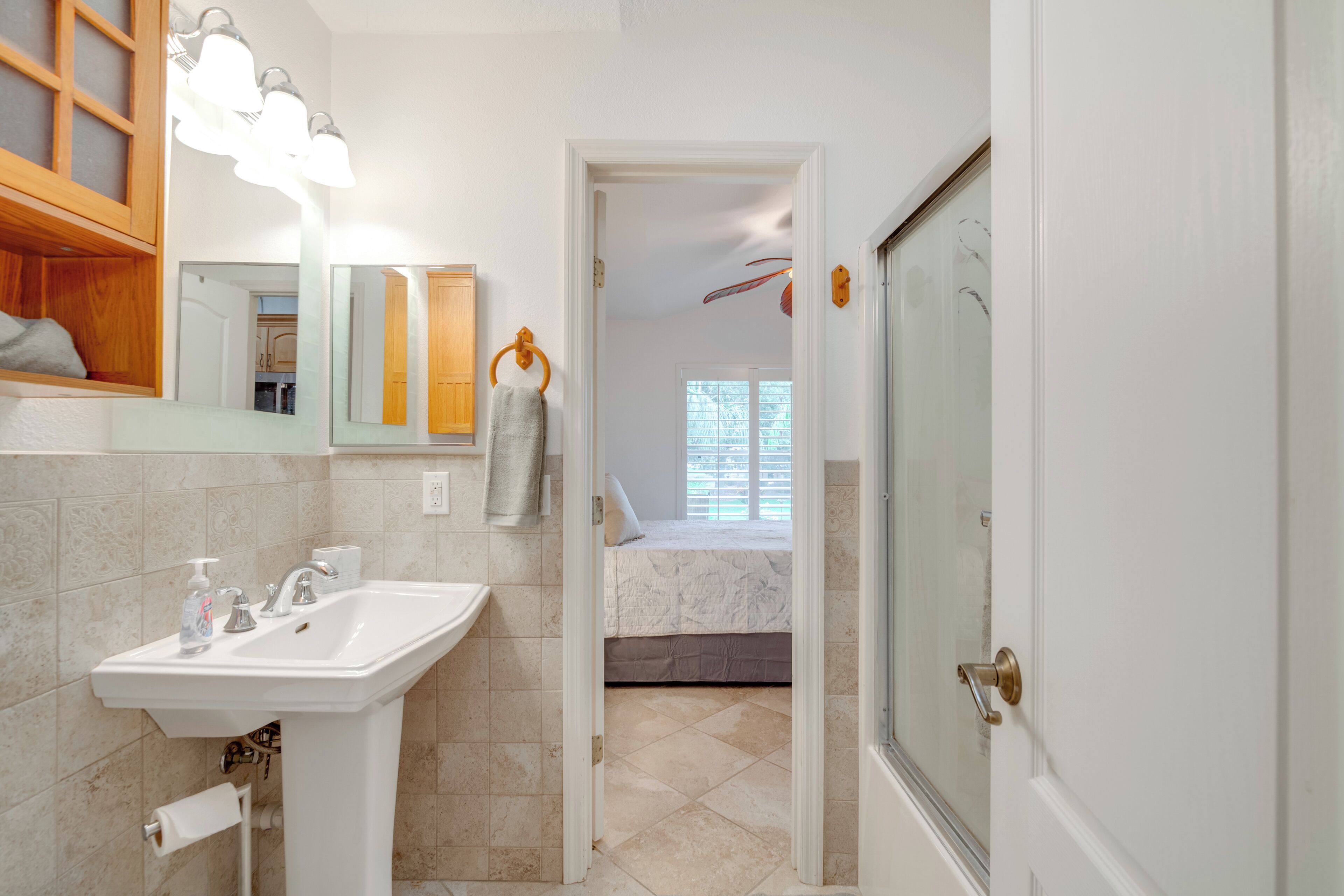 A bathroom with a sink, mirror, and towel rack.