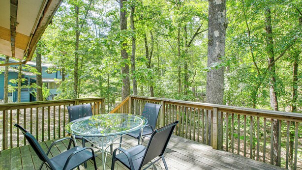 A wooden deck with a glass table and chairs, surrounded by trees. - 1/2 Mi to Desoto Lake: Hot Springs Village Home (Hot Springs Village)