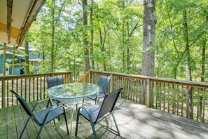 A wooden deck with a glass table and chairs, surrounded by trees. - 1/2 Mi to Desoto Lake: Hot Springs Village Home (Hot Springs Village)