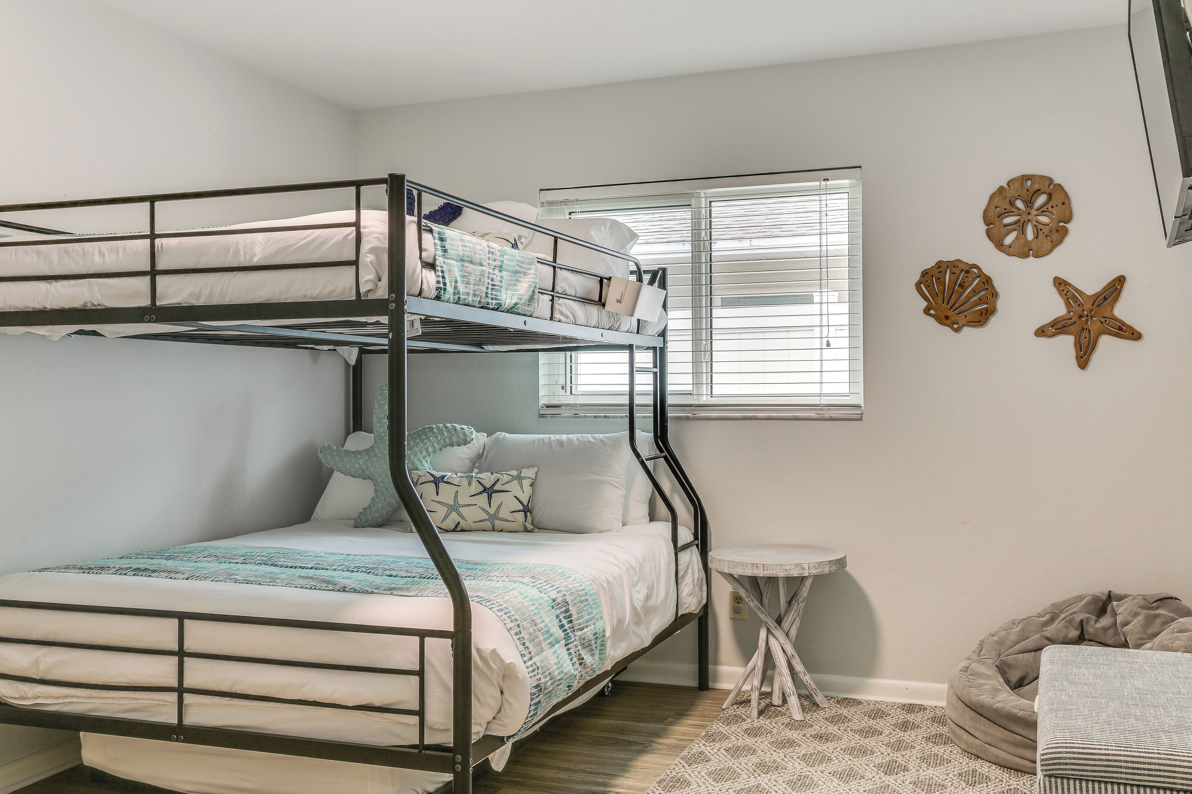 A bunk bed room with a small table and a bean bag chair.